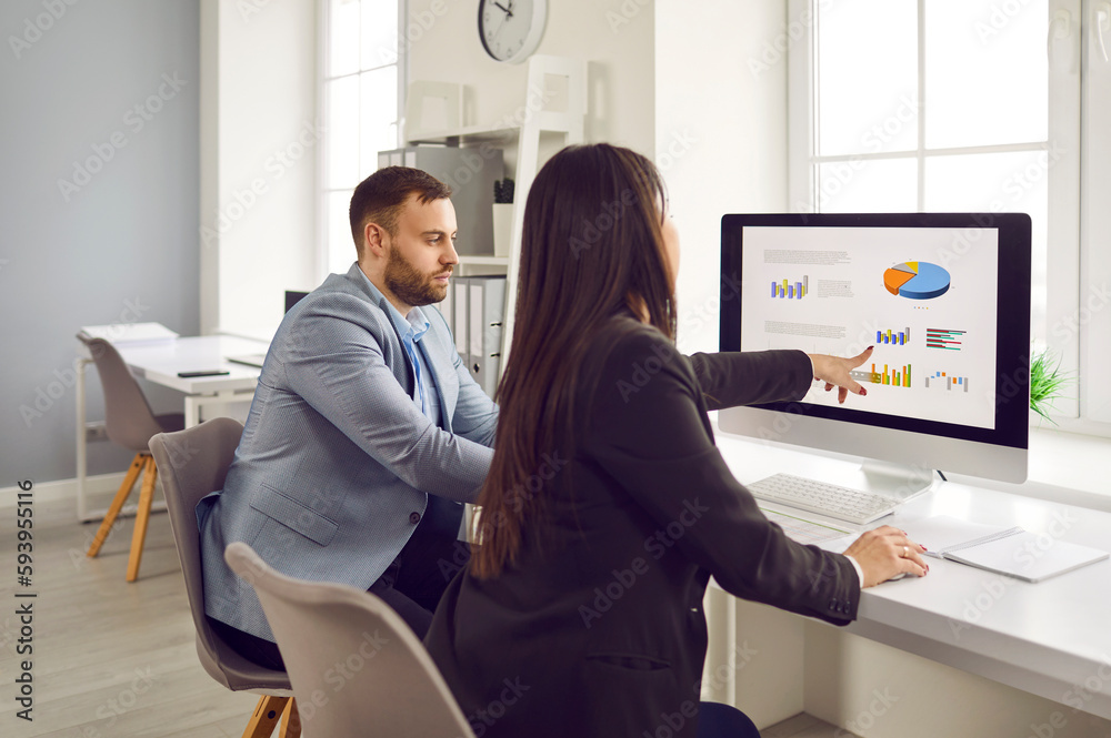 Business professionals analyze performance metrics on a data visualization screen, highlighting the role of analytics in modern corporate decision-making.
