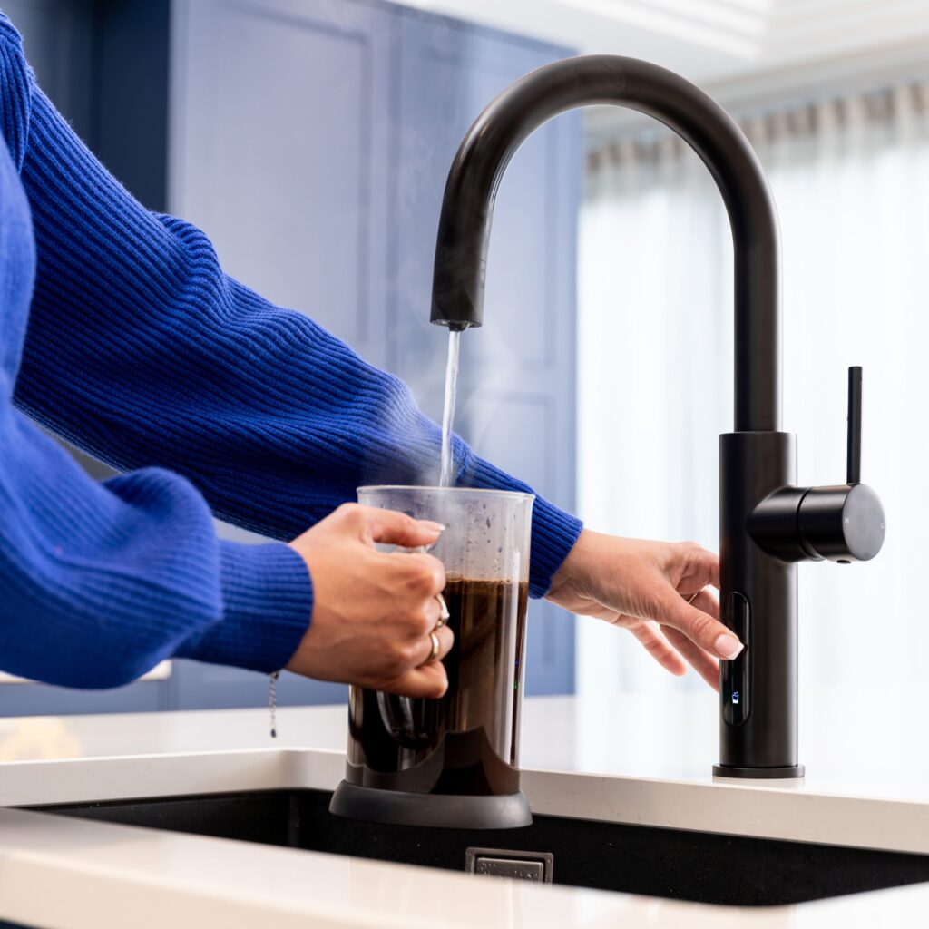 A modern smart faucet in a home kitchen, highlighting the digital connectivity of everyday appliances that can be vulnerable to cyberattacks.