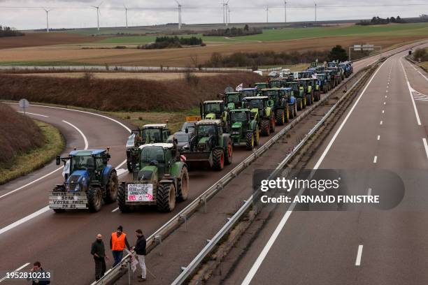 French farmers stage a road blockade with tractors along a major highway, protesting government measures on cattle culling.