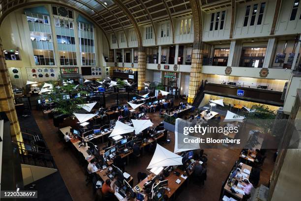 Traders work in a busy trading floor, reflecting the dynamic economic environment amid looming global uncertainties.