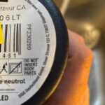 A consumer holds a bottle with Swiss branding, highlighting the scrutiny on bottled water safety in Europe following a major contamination scandal.