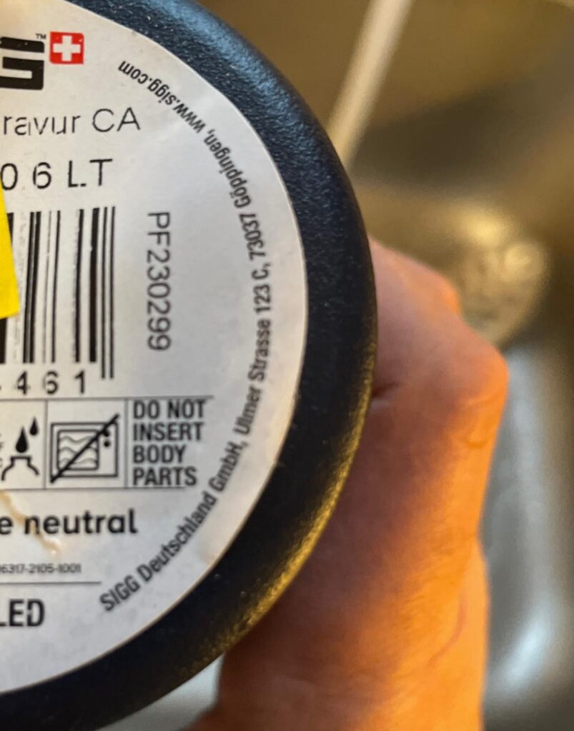 A consumer holds a bottle with Swiss branding, highlighting the scrutiny on bottled water safety in Europe following a major contamination scandal.