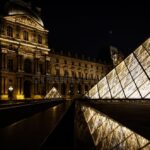 The Louvre Museum at night, a symbol of Europe's cultural heritage, now under scrutiny following a daring burglary that raises urgent questions about the security of its priceless collections.